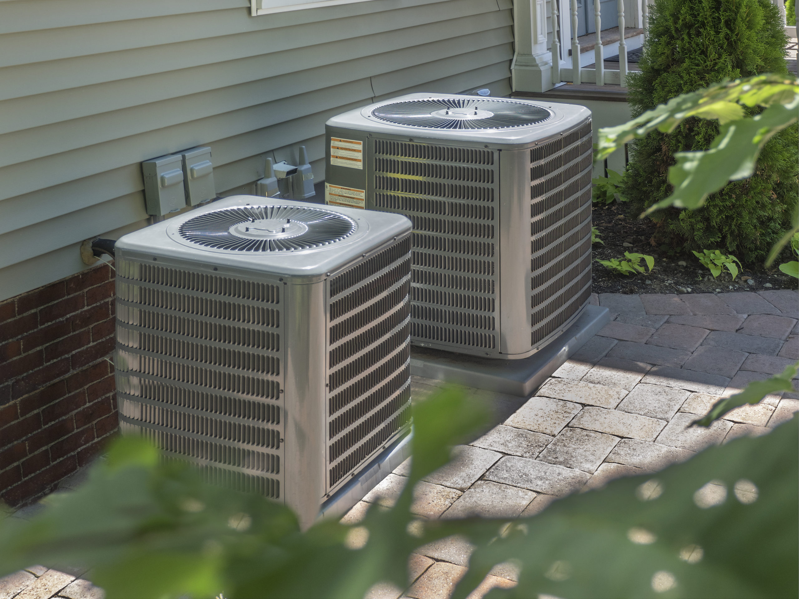 Two air conditioning units outside of a home