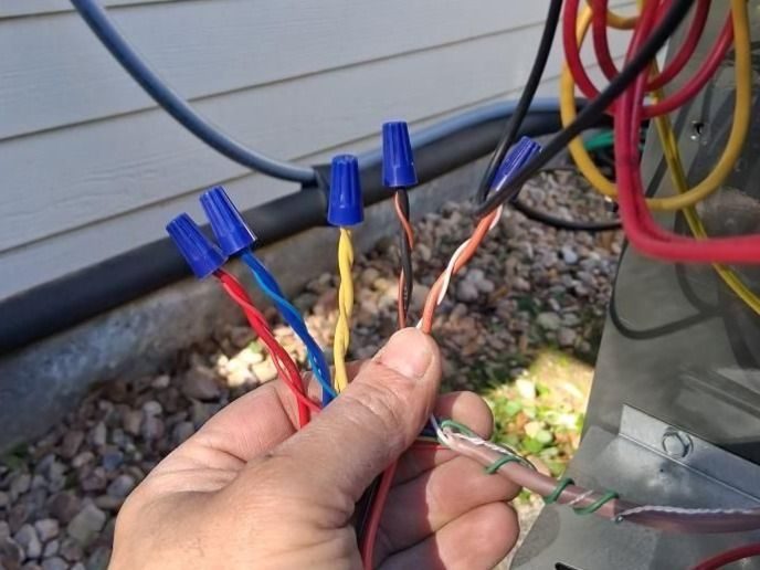 Professional electrician making code corrections on outdoor wires