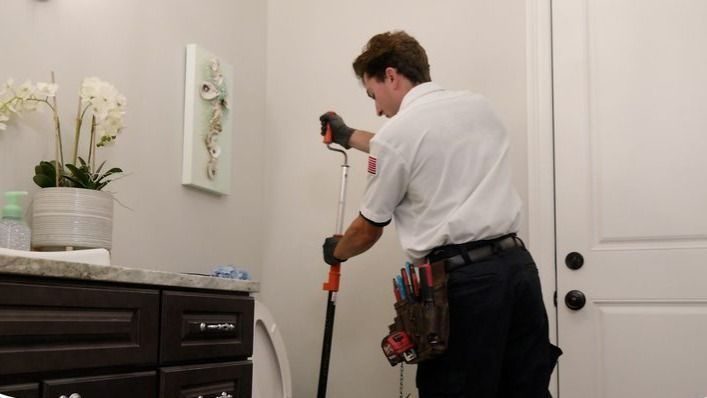 Stuart technician cleaning a clog from a home bathroom toilet.