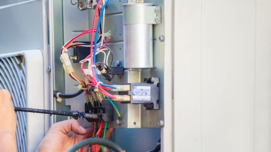 Tech repairing outdoor AC unit wiring