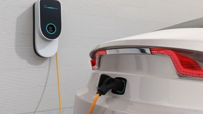 EV charger newly installed in garage charging a car.