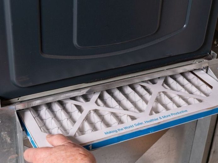 Tech replacing dirty furnace filter in home