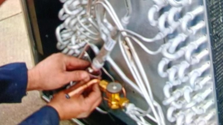 Stuart technician repairing a heating unit with the coils showing