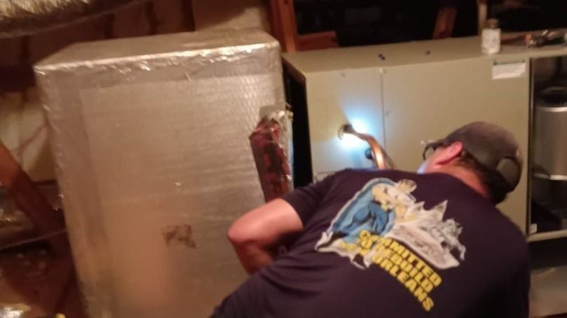 Stuart professional working on an HVAC in the attic.