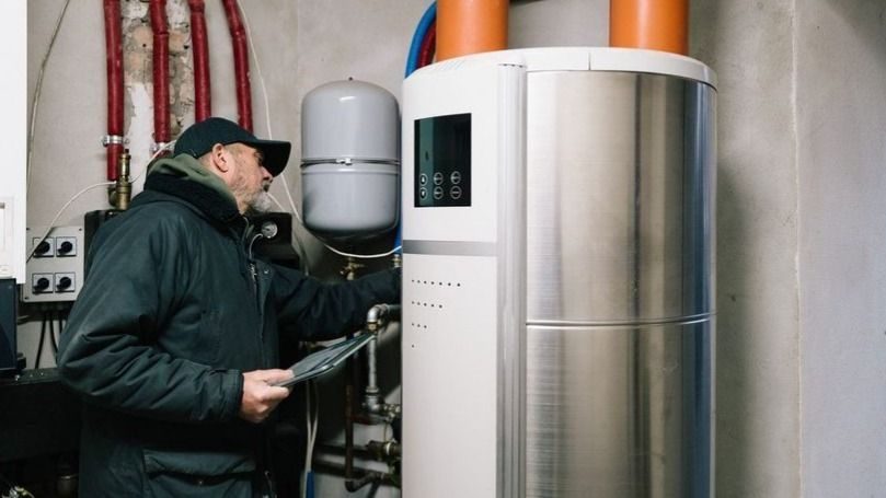 technician inspects water heating system