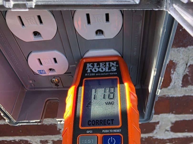 Professional technician testing an outside outlet.
