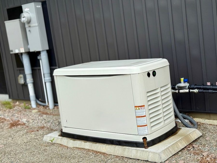 Generator on the side of a house on a concrete slab